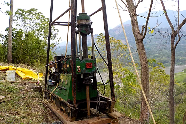 Equipo de perforación en una zona boscosa de montaña.